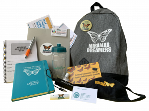 Bookbag with the Dreamers Support Program logo pictured with various school supplies and swag items.