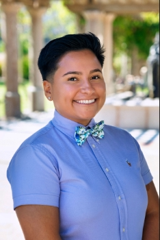 Smiling person with short dark hair and blue shirt